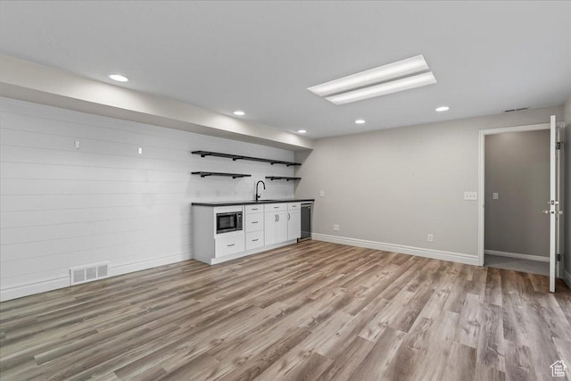 8022 S Deer Creek Rd E, Cottonwood Heights, UT 84121 - unfurnished living room with bar with sink, light wood-style flooring, and recessed lighting