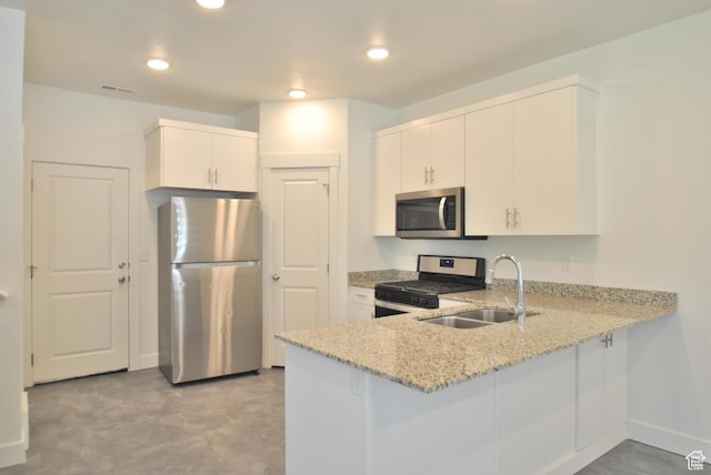 1183 W 1820 S, Logan, UT 84321 - kitchen with stainless steel appliances, a peninsula, light stone counters, recessed lighting, and white cabinetry