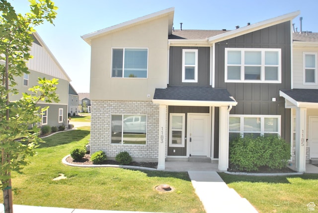 1183 W 1820 S, Logan, UT 84321 - townhome / multi-family property with board and batten siding, a front yard, a shingled roof, and brick siding