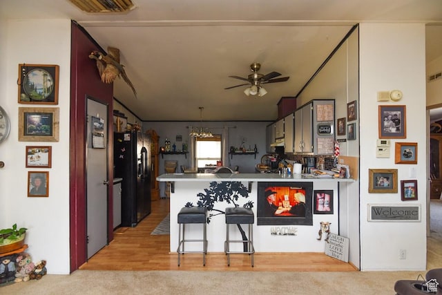 93 N Sherman St, Stockton, UT 84071 - kitchen featuring black fridge, a peninsula, ceiling fan, a chandelier, and a kitchen bar