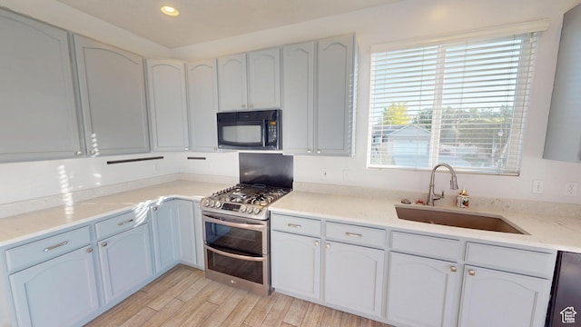 13333 S Alonzo Ln W, Herriman, UT 84096 - kitchen with black microwave, range with two ovens, dishwasher, recessed lighting, and light wood-type flooring