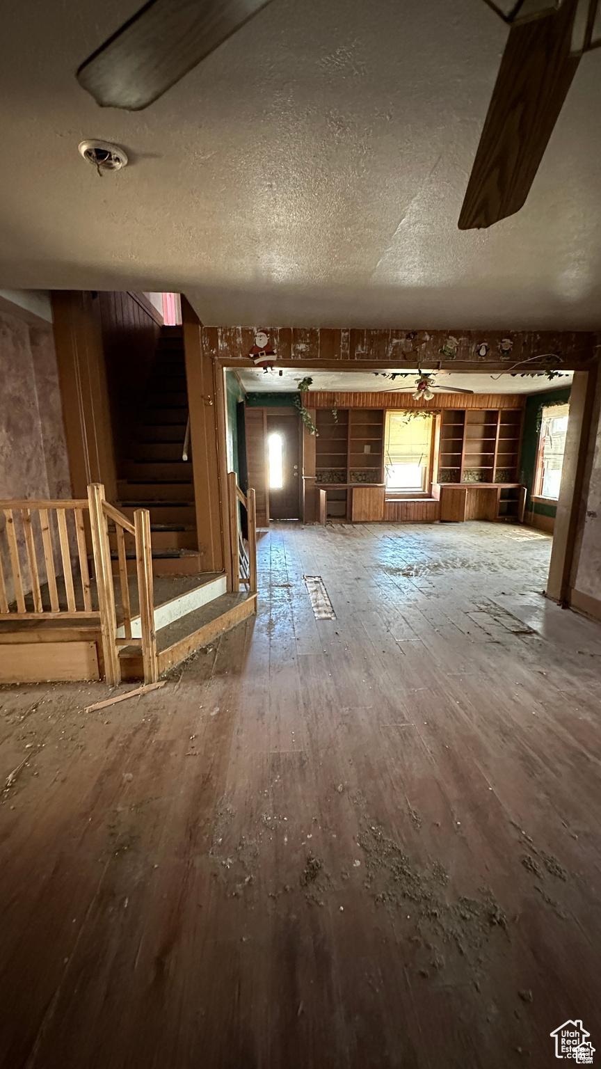 637 E Main St, Grantsville, UT 84029 - unfurnished living room featuring wood-type flooring, stairway, and a textured ceiling