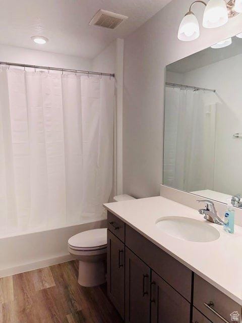 2944 W Ezra Dr, Cedar City, UT 84720 - bathroom with vanity, wood finished floors, and shower / bathtub combination with curtain