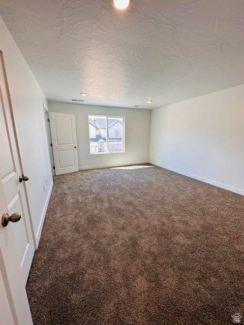 2944 W Ezra Dr, Cedar City, UT 84720 - carpeted spare room featuring a textured ceiling and baseboards