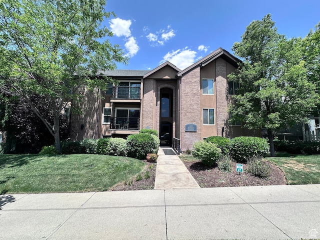 963 E 800 S Unit 106, Salt Lake City, UT 84102 - view of front of house featuring a front yard, stucco siding, and a balcony