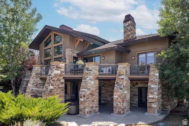2711 E Bitter Brush Dr, Park City, UT 84098 - rear view of house with a balcony, a chimney, and stone siding