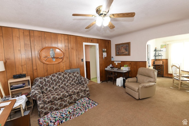 2758 Fowler Ave, Ogden, UT 84403 - living room featuring wooden walls, carpet floors, a ceiling fan, arched walkways, and wainscoting