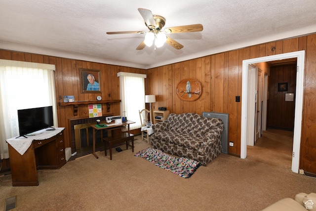 2758 Fowler Ave, Ogden, UT 84403 - carpeted living area featuring healthy amount of natural light, a ceiling fan, wooden walls, and a desk