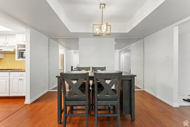 5544 S Springtree Ln E Unit H, Salt Lake City, UT 84107 - dining space with wood finished floors, a chandelier, and a raised ceiling
