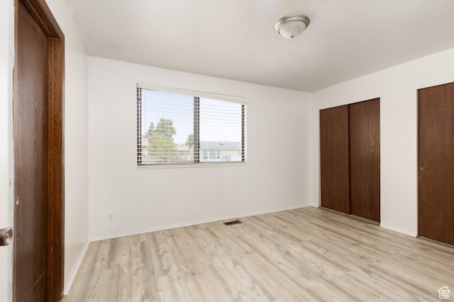 3453 W 5700 S, Taylorsville, UT 84129 - unfurnished bedroom with light wood-type flooring and two closets