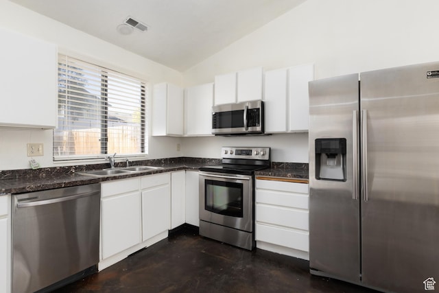 3453 W 5700 S, Taylorsville, UT 84129 - kitchen featuring stainless steel appliances, lofted ceiling, dark countertops, and white cabinetry