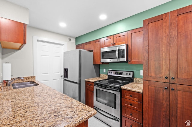 2095 S Main E Unit 5, Bountiful, UT 84010 - kitchen featuring stainless steel appliances, light stone counters, brown cabinetry, and recessed lighting