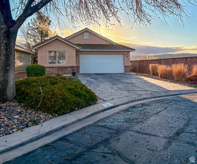 2930 E 450 N Unit F24, St George, UT 84790 - view of front facade with brick siding, stucco siding, concrete driveway, and a garage