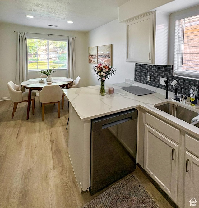 2930 E 450 N Unit F24, St George, UT 84790 - kitchen featuring dishwashing machine, light wood-type flooring, backsplash, white cabinetry, and light stone countertops