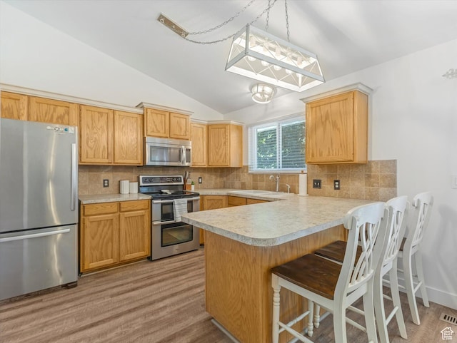 4736 S 2675 W, Roy, UT 84067 - kitchen featuring appliances with stainless steel finishes, light countertops, vaulted ceiling, a peninsula, and backsplash