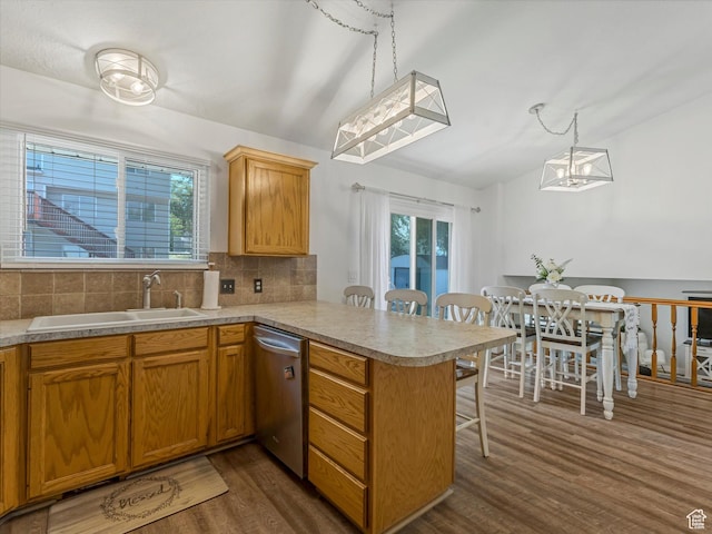 4736 S 2675 W, Roy, UT 84067 - kitchen with stainless steel dishwasher, dark wood-type flooring, a peninsula, a breakfast bar, and backsplash