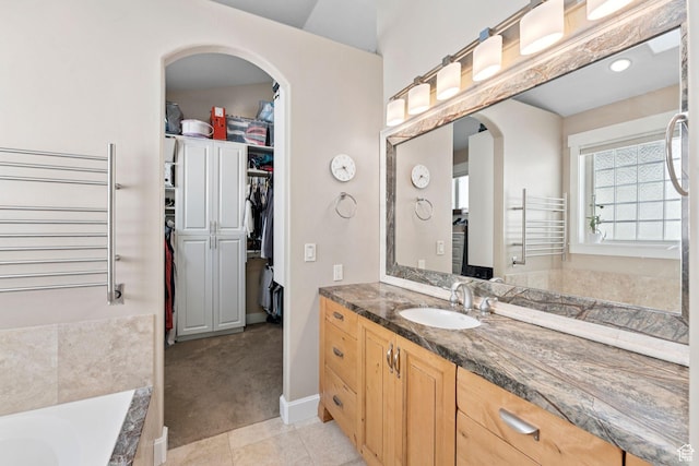 3231 E Lantern Hill Ct S, Cottonwood Heights, UT 84093 - full bath featuring vanity, a bath, a spacious closet, a towel warmer, and tile patterned floors