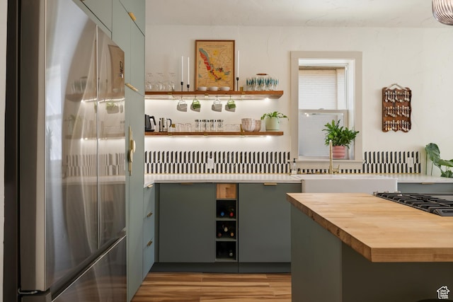 922 S 400 E, Salt Lake City, UT 84111 - kitchen view of stainless steel refrigerator, open shelves, butcher block countertops, light wood finished floors, and bar area