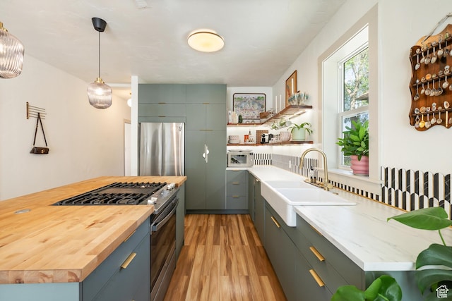 922 S 400 E, Salt Lake City, UT 84111 - kitchen featuring stainless steel appliances, wood counters, light wood-style floors, open shelves, and hanging light fixtures