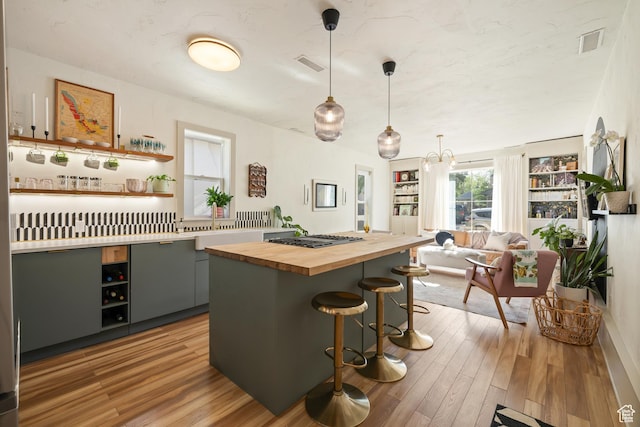 922 S 400 E, Salt Lake City, UT 84111 - kitchen with butcher block counters, stainless steel gas stovetop, open shelves, and a kitchen breakfast bar