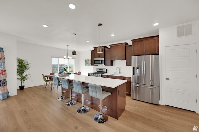 672 E 730 N Unit 25, Hyrum, UT 84319 - kitchen with appliances with stainless steel finishes, a kitchen breakfast bar, a kitchen island, recessed lighting, and light countertops