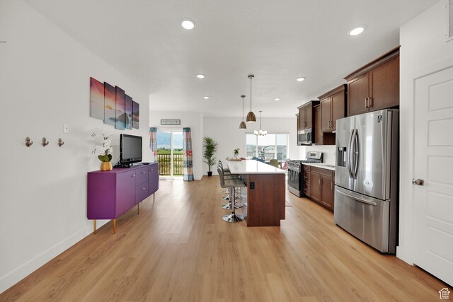 672 E 730 N Unit 25, Hyrum, UT 84319 - kitchen with appliances with stainless steel finishes, a breakfast bar, light wood-style floors, a center island, and recessed lighting