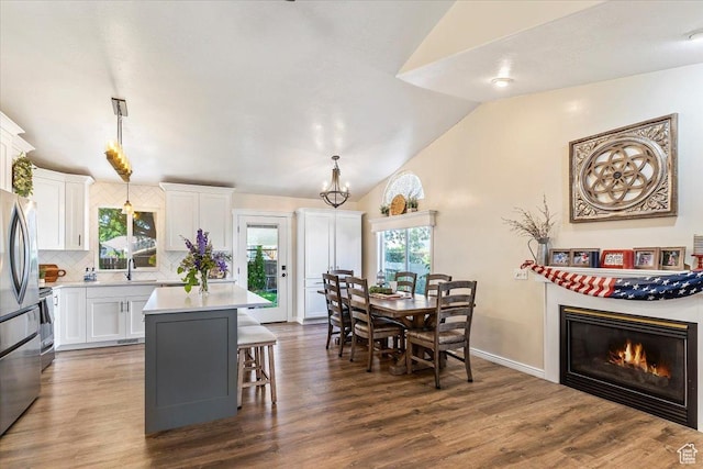 883 E 1775 N, North Ogden, UT 84414 - kitchen with vaulted ceiling, decorative backsplash, white cabinets, light countertops, and a kitchen bar