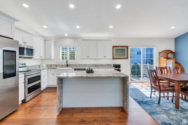 2541 S 1400 W, Woods Cross, UT 84087 - kitchen with appliances with stainless steel finishes, light wood-style flooring, a kitchen island, white cabinetry, and recessed lighting