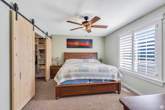 2541 S 1400 W, Woods Cross, UT 84087 - carpeted bedroom featuring a barn door, a spacious closet, a ceiling fan, a closet, and a textured ceiling
