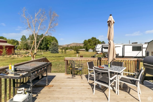 586 W 300 N, Fountain Green, UT 84632 - wooden deck with outdoor dining area, a lawn, and a mountain view
