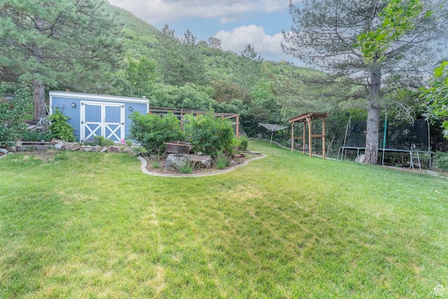 2582 Jacqueline Dr E, Ogden, UT 84403 - view of green lawn with a trampoline, a shed, and a view of trees