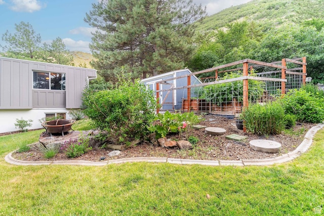 2582 Jacqueline Dr E, Ogden, UT 84403 - view of green lawn featuring a fire pit, a garden, an outbuilding, and a mountain view