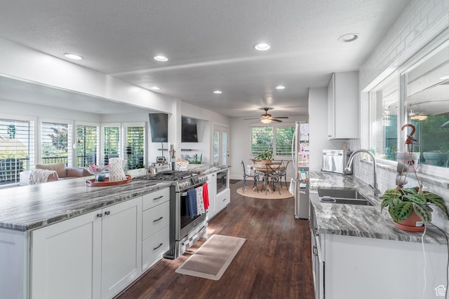 2582 Jacqueline Dr E, Ogden, UT 84403 - kitchen with stainless steel range with gas cooktop, dark wood-style flooring, freestanding refrigerator, recessed lighting, and light stone counters