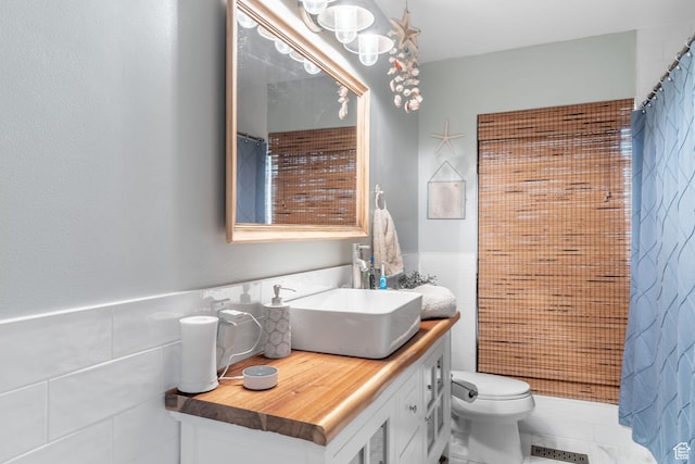 2582 Jacqueline Dr E, Ogden, UT 84403 - bathroom featuring tile walls, vanity, a shower with shower curtain, and a wainscoted wall