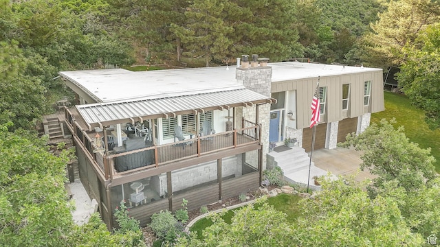 2582 Jacqueline Dr E, Ogden, UT 84403 - view of front facade featuring a chimney, a garage, and a view of trees