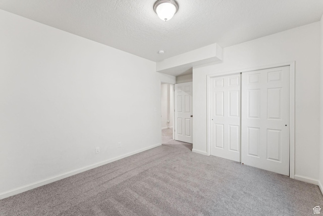 5488 W Tower Arch Ln, Herriman, UT 84096 - unfurnished bedroom featuring a textured ceiling, carpet, and a closet