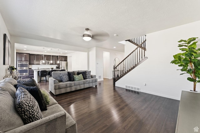 5488 W Tower Arch Ln, Herriman, UT 84096 - living area featuring dark wood finished floors, stairs, ceiling fan, a textured ceiling, and recessed lighting