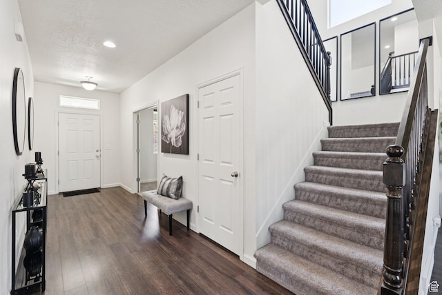 5488 W Tower Arch Ln, Herriman, UT 84096 - foyer entrance featuring dark wood finished floors, stairs, recessed lighting, plenty of natural light, and a textured ceiling