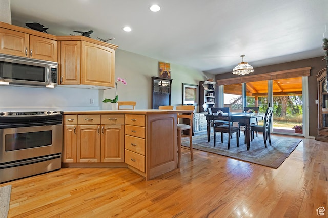 8216 S Scandia Way, Sandy, UT 84093 - kitchen with stainless steel appliances, a peninsula, light wood finished floors, recessed lighting, and a chandelier
