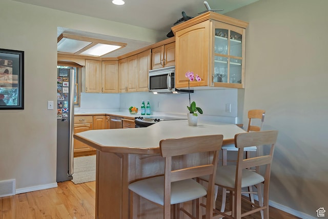 8216 S Scandia Way, Sandy, UT 84093 - kitchen featuring stainless steel appliances, a kitchen breakfast bar, glass insert cabinets, a peninsula, and light countertops