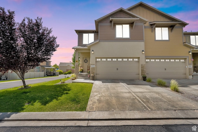 3951 W Sage Blossom Way S, Jordan, UT 84009 - view of front of home featuring stone siding, a front lawn, a garage, and concrete driveway