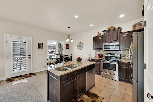 3951 W Sage Blossom Way S, Jordan, UT 84009 - kitchen with appliances with stainless steel finishes, light tile patterned floors, decorative backsplash, a center island with sink, and dark brown cabinets