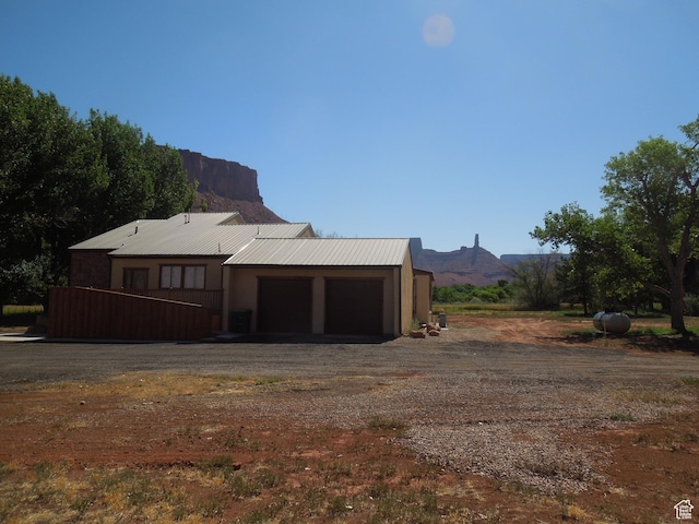 426 N Amber Ln N Unit 426, Castle Valley, UT 84532 - back of property featuring a garage, driveway, a mountain view, and a metal roof