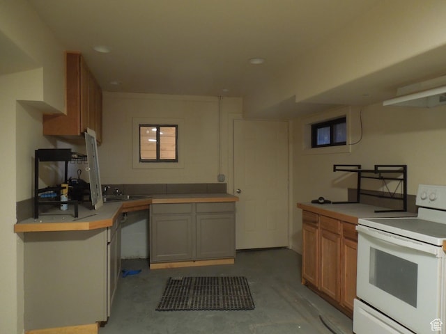 426 N Amber Ln N Unit 426, Castle Valley, UT 84532 - kitchen featuring white range with electric cooktop, unfinished concrete flooring, light countertops, brown cabinetry, and recessed lighting
