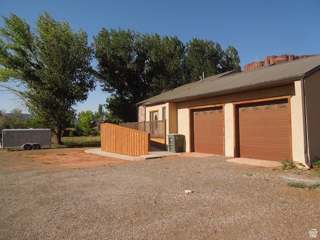 426 N Amber Ln N Unit 426, Castle Valley, UT 84532 - view of side of home with stucco siding, a metal roof, driveway, and an attached garage