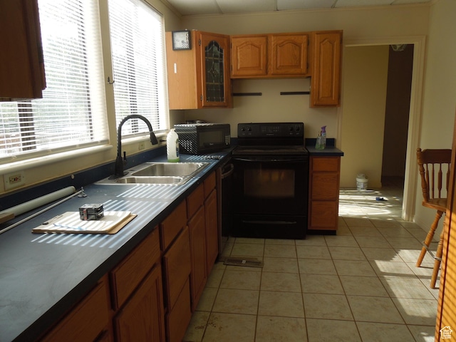426 N Amber Ln N Unit 426, Castle Valley, UT 84532 - kitchen with black appliances, light tile patterned flooring, dark countertops, and brown cabinetry