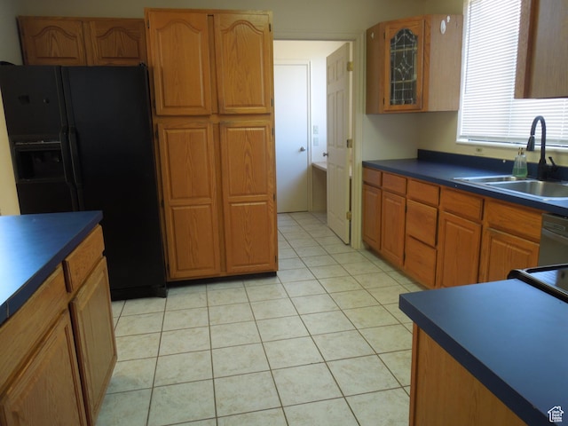 426 N Amber Ln N Unit 426, Castle Valley, UT 84532 - kitchen with black fridge with ice dispenser, dark countertops, brown cabinetry, light tile patterned floors, and dishwasher
