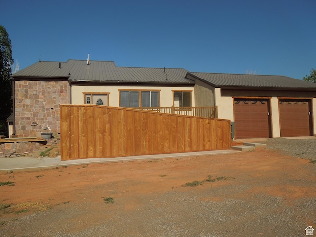 426 N Amber Ln N Unit 426, Castle Valley, UT 84532 - view of front of house featuring a metal roof, driveway, stucco siding, a garage, and stone siding