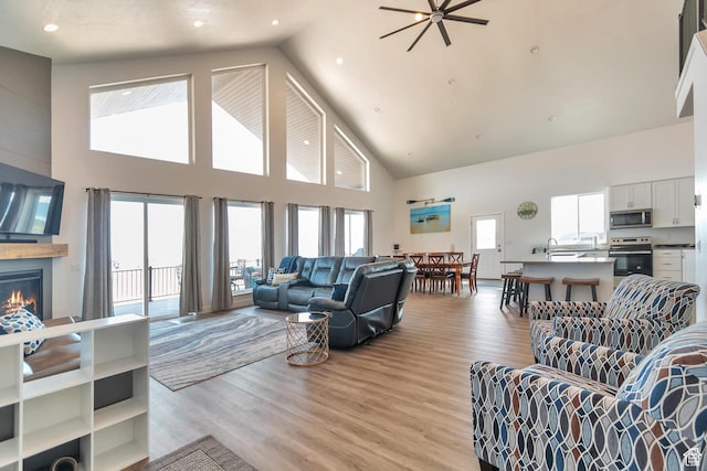248 W Chukar Cir Unit 18, Garden City, UT 84028 - living area featuring high vaulted ceiling, a large fireplace, light wood-style flooring, and a ceiling fan