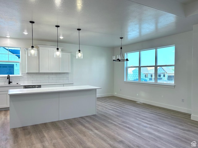 82 N 500 W, Gunnison, UT 84634 - kitchen featuring light wood-style flooring, a center island, light countertops, decorative backsplash, and white cabinetry